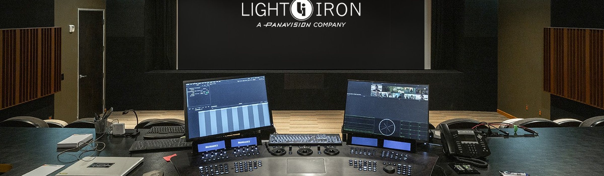 Color grading theater at Light Iron, with scopes and a shot grid on the operator monitors, a grading panel, and the reference screen beyond